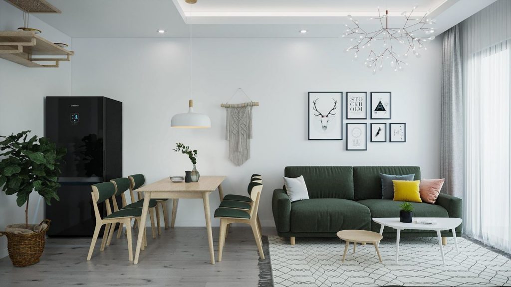 Tại không gian phòng khách của căn hộ 60m2 thiết kế theo phong cách Bắc Âu (Scandinavian), KTS đã khéo léo bố trí thêm bộ bàn ăn cùng tủ lạnh hòa quyện để tái hiện một bức tranh phong cảnh Bắc Âu với bức tường màu trắng, bộ sofa và bàn ghế ăn gỗ kết hợp lót đệm màu rêu và sàn gỗ độc đáo. Điểm nhấn của không gian được tạo ra từ các đồ vật trang trí như chùm đèn “vô hình”, thảm trải sàn vải kiểu mang tới vẻ đẹp mộc mạc, tự do pha trộn một chút hoang dã.